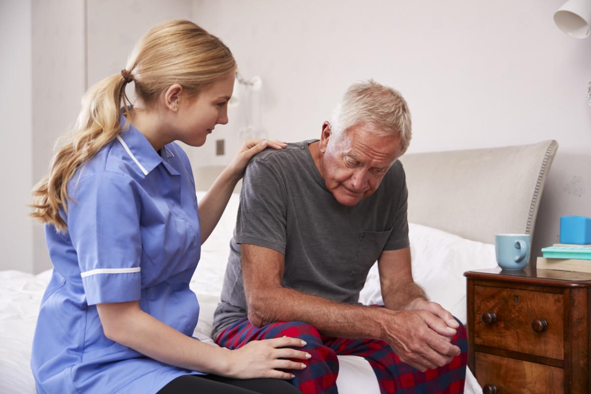 Nurse Making Home Visit To Senior Man Suffering With Depression stock photo